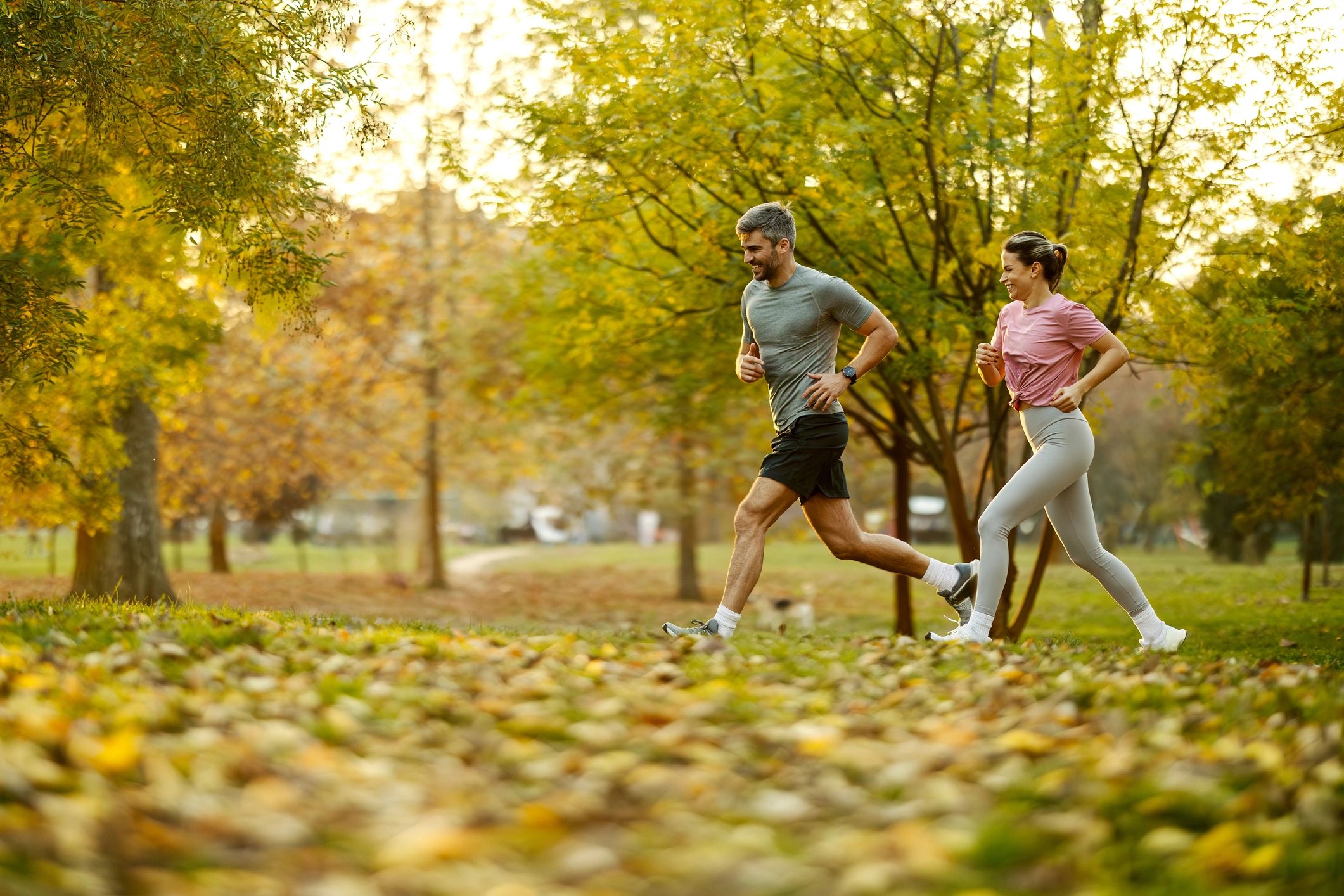Couple jogging together in a park wearing sportswear