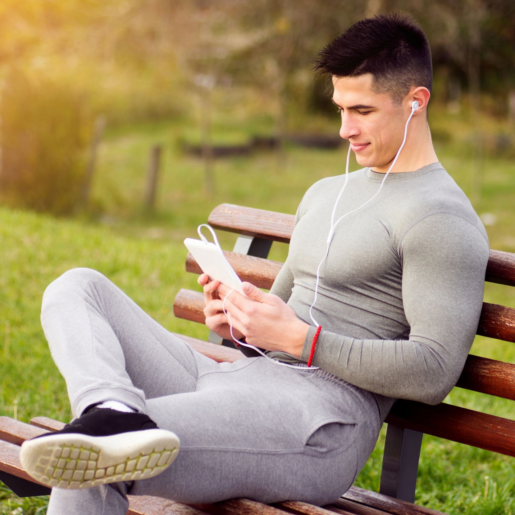 Sporty man outdoors with tablet and earphones