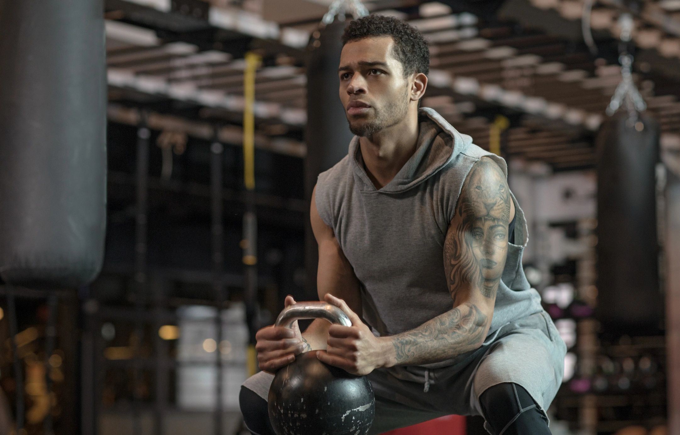 Athlete training with kettlebell in gym wearing activewear