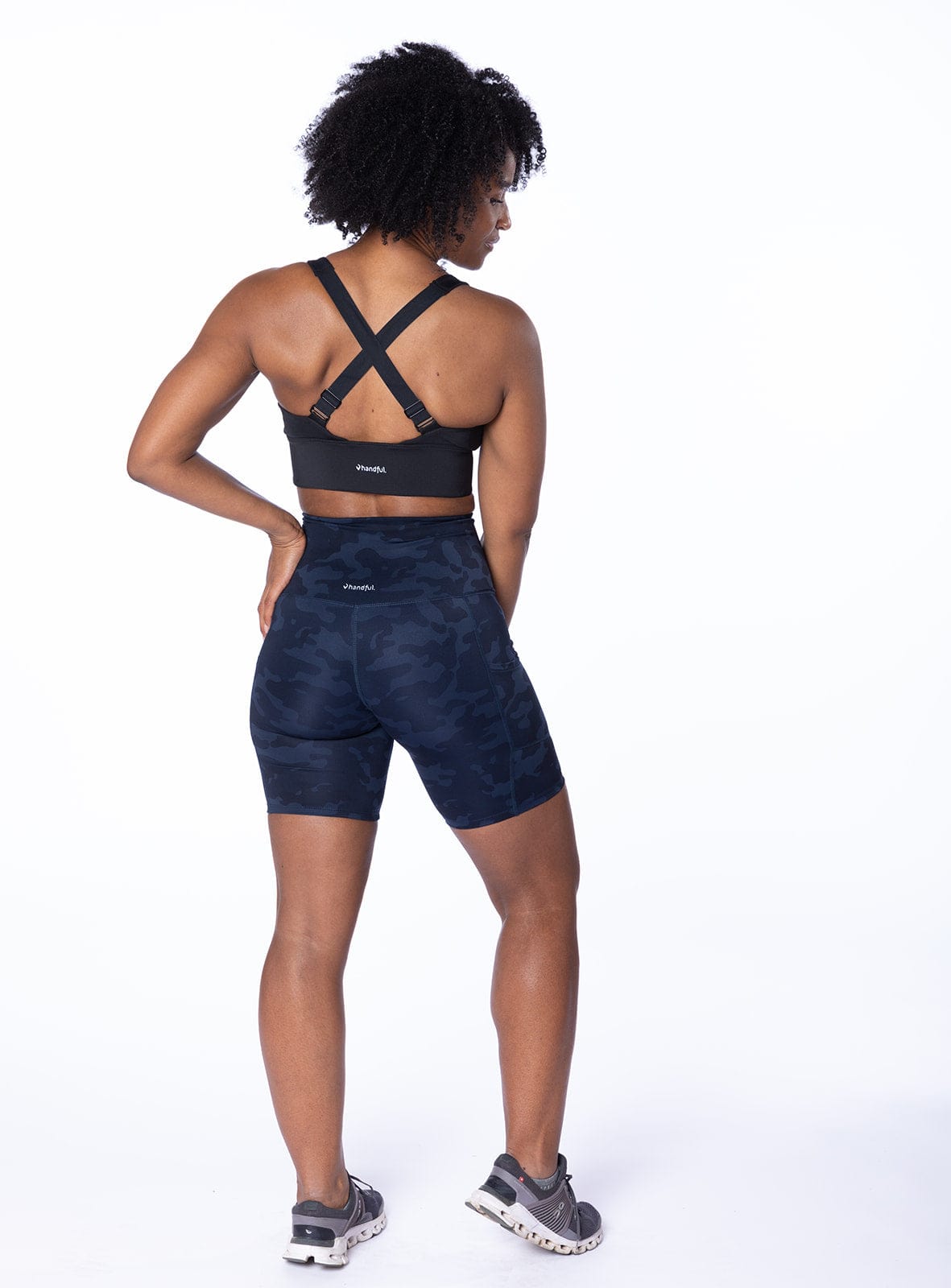 Woman wearing purple activewear shorts from the back in a studio pose